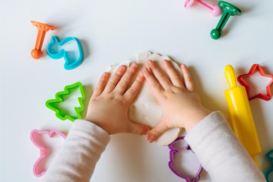 Ones Movers Preschool Class, One year old preschoolers hand splaying with pay doh